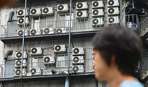 전국적으로 무더위가 기승을 부리는 가운데 3일 오후 한 시민이 서울 중구 에어컨 실외기들이 설치된 건물 앞을 지나가고 있다. 한국소비자원은 에어컨 화재사고의 주 원인을 분석한 결과 에어컨 실외기가 화재의 주범이라 밝혔다. [사진=뉴시스]