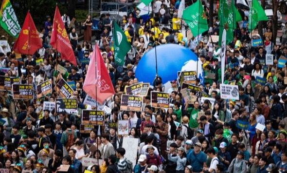 국제 기후 파업 주간인 21일 오후 서울 종로구 종각역 사거리에서 열린 9.21 기후위기 비상행동 참가자들이 '기후 위기가 다가오면 생존의 위협이 다가온다'는 의미를 가진 퍼포먼스를 마친 후 집회를 하고 있다