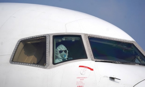 마스크가 달린 조종사가 코로나 바이러스가 발생했을 때 우한 티안 허 국제 공항 하역장에 항공기를 주차합니다. 사진 : 신화 / Barcroft Media